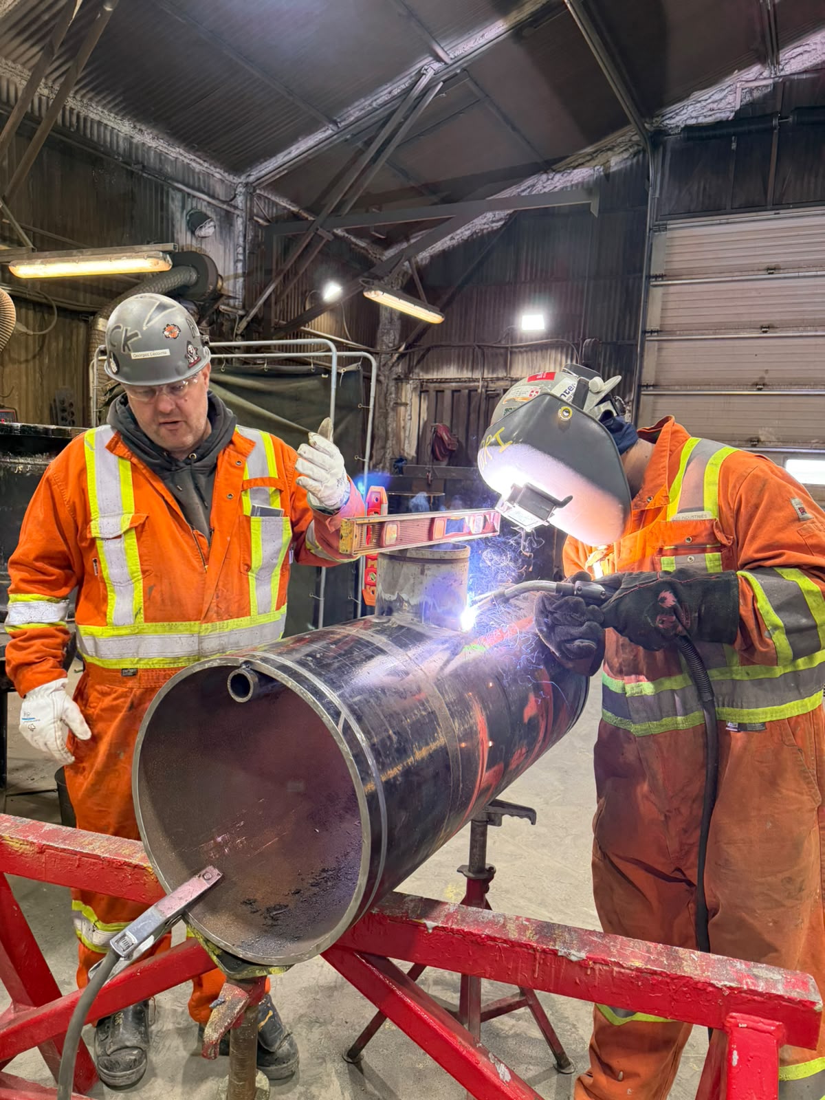 Soudeur et tuyauteur travaillant ensemble sur une conduite à la mine Raglan